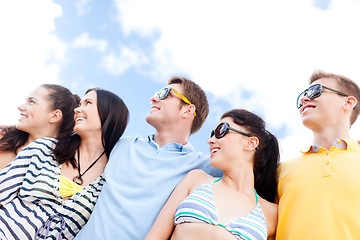 Image showing group of happy friends hugging on beach