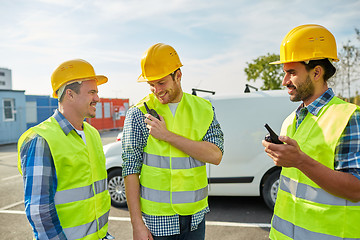 Image showing happy male builders in vests with walkie talkie