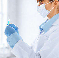 Image showing female doctor holding syringe with injection