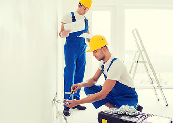 Image showing builders with tablet pc and equipment indoors