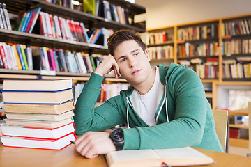 Image showing bored student or young man with books in library