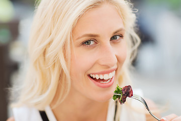 Image showing happy woman eating dinner at restaurant terrace