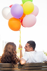 Image showing happy couple with air balloons in city