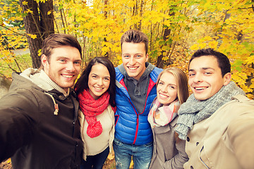 Image showing group of smiling men and women in autumn park