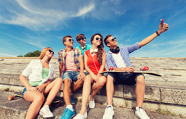 Image showing group of smiling friends with smartphone outdoors