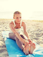 Image showing young woman making yoga exercises outdoors