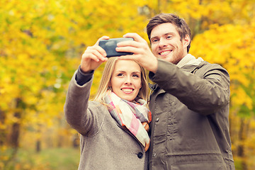 Image showing smiling couple hugging in autumn park