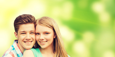 Image showing smiling couple hugging over green background