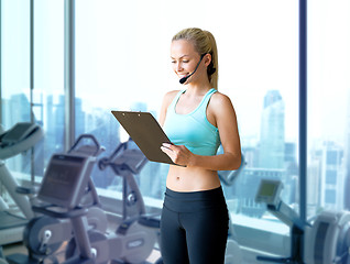 Image showing happy woman trainer with microphone and clipboard