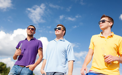 Image showing happy friends drinking beer and walking on beach