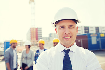 Image showing group of smiling builders in hardhats outdoors