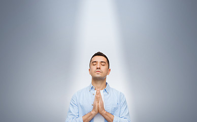 Image showing man praying under ray of ligh