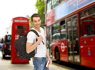 Image showing happy young man with backpack and book travelling