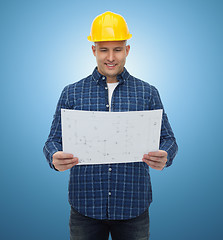 Image showing smiling male builder in helmet with blueprint