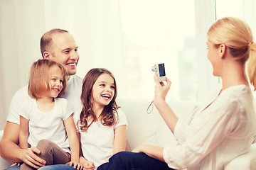 Image showing mother taking picture of father and daughters