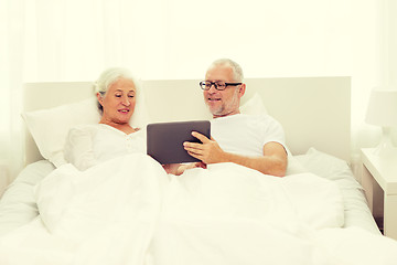 Image showing happy senior couple with tablet pc at home