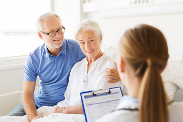 Image showing senior woman and doctor with clipboard at hospital