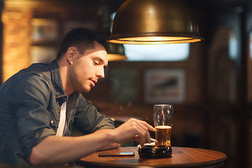 Image showing man drinking beer and smoking cigarette at bar