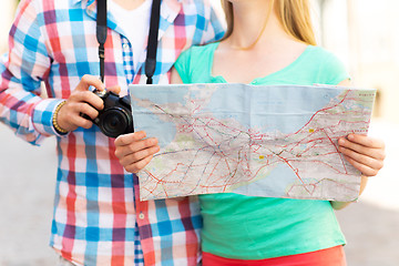 Image showing close up of couple with map and camera in city