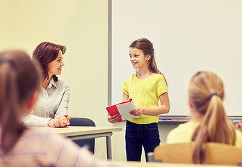 Image showing group of school kids with teacher in classroom