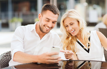 Image showing happy couple with smatphone at city street cafe