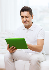 Image showing smiling man working with tablet pc at home