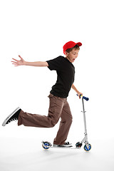Image showing Happy boy riding a scooter