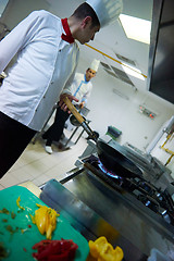 Image showing chef in hotel kitchen prepare food with fire