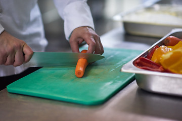 Image showing chef in hotel kitchen  slice  vegetables with knife