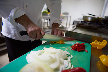 Image showing chef in hotel kitchen  slice  vegetables with knife