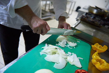 Image showing chef in hotel kitchen  slice  vegetables with knife