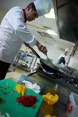 Image showing chef in hotel kitchen prepare food with fire