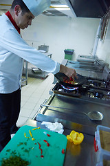 Image showing chef in hotel kitchen prepare food with fire