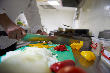 Image showing chef in hotel kitchen  slice  vegetables with knife