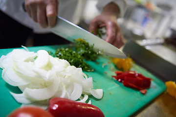 Image showing chef in hotel kitchen  slice  vegetables with knife