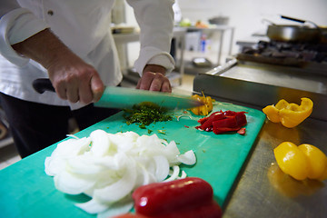 Image showing chef in hotel kitchen  slice  vegetables with knife