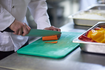 Image showing chef in hotel kitchen  slice  vegetables with knife