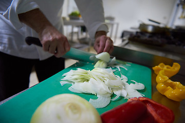 Image showing chef in hotel kitchen  slice  vegetables with knife