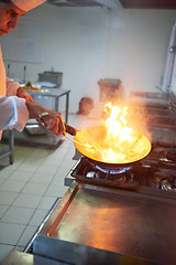 Image showing chef in hotel kitchen prepare food with fire