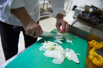 Image showing chef in hotel kitchen  slice  vegetables with knife