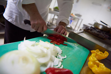 Image showing chef in hotel kitchen  slice  vegetables with knife