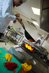 Image showing chef in hotel kitchen prepare food with fire