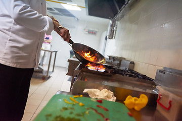 Image showing chef in hotel kitchen prepare food with fire