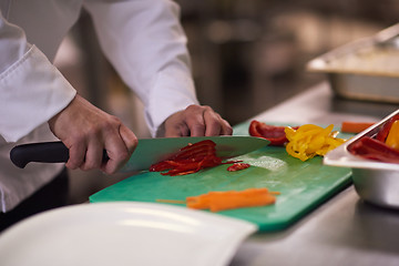 Image showing chef in hotel kitchen  slice  vegetables with knife