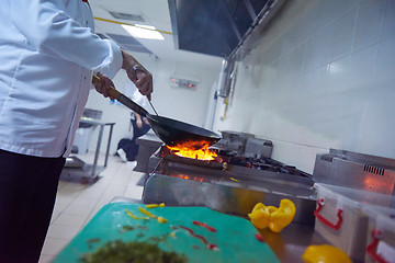 Image showing chef in hotel kitchen prepare food with fire
