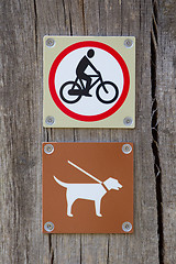 Image showing Forbidden to cycle an dog on a leash 