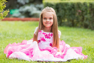 Image showing Girl princess sat on the lawn in the green garden