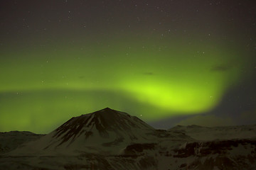 Image showing Northern lights with snowy mountains in the foreground