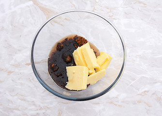 Image showing Maple syrup, butter and dark soft sugar in a glass bowl