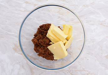 Image showing Pats of butter with dark soft sugar in a bowl